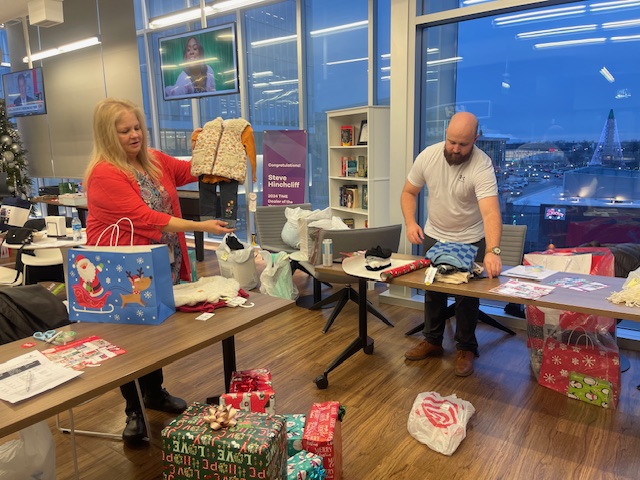 Associates wrapping holiday gifts together in the office — giving back and celebrating the season