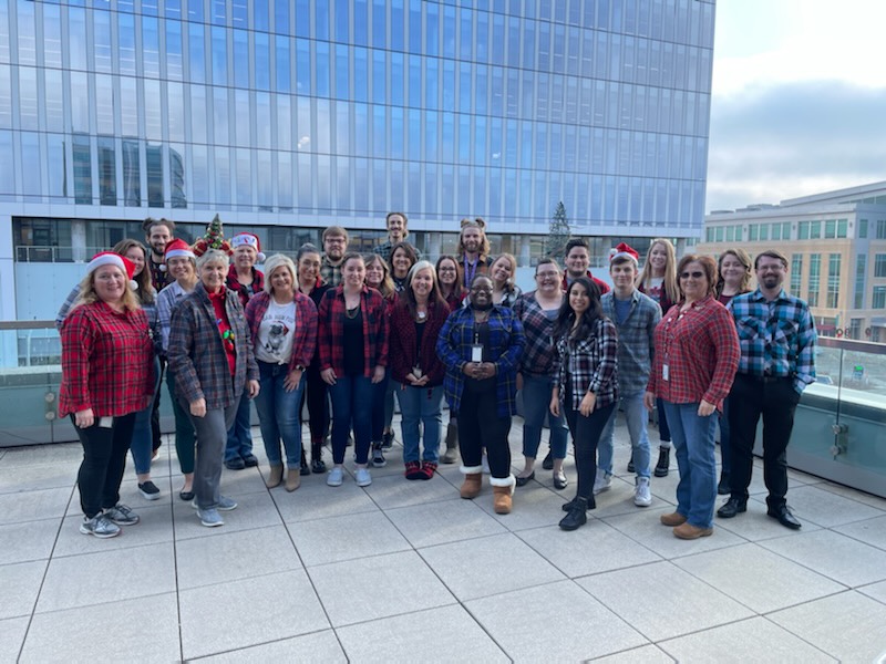 The whole team together in flannel and Santa hats for a holiday spirit day on the rooftop